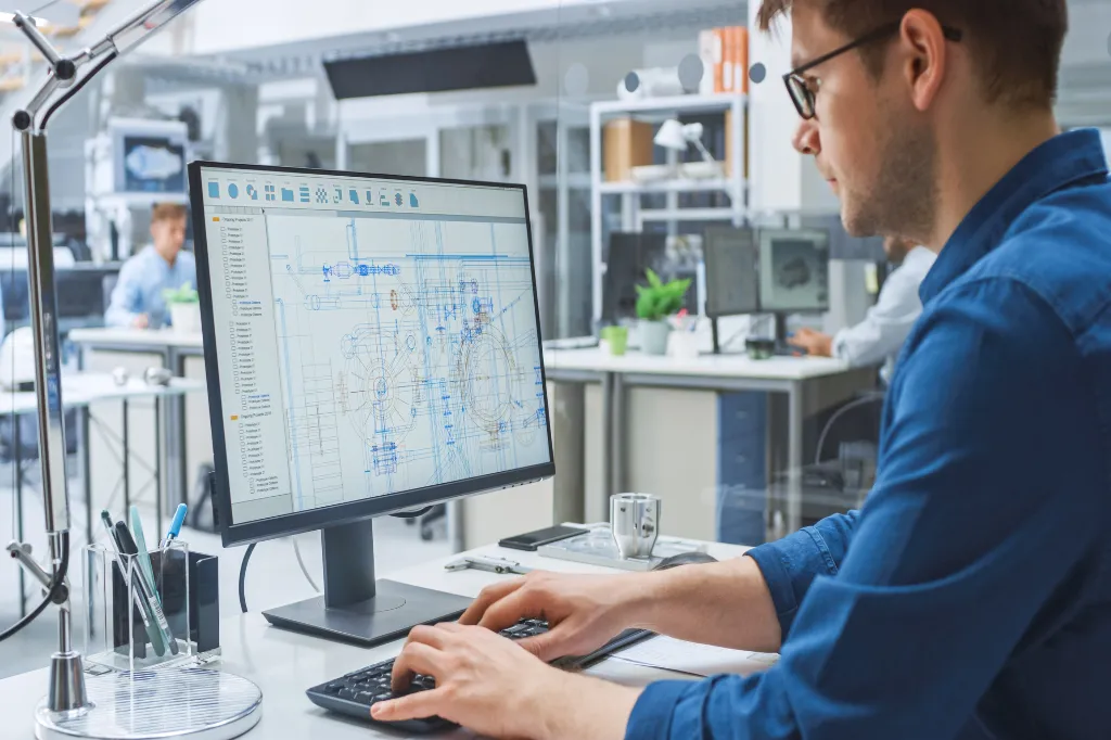 A man working on technical build plans on a computer