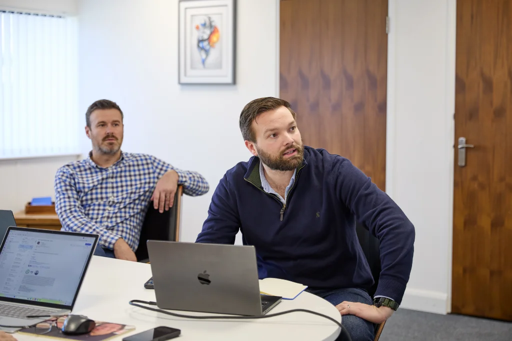 SJH colleagues in office meeting discussing client project plans