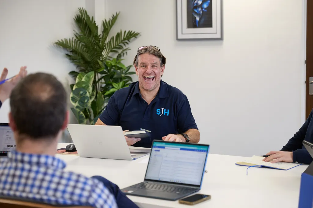 Team meeting in an office with laptops and notes during a discussion