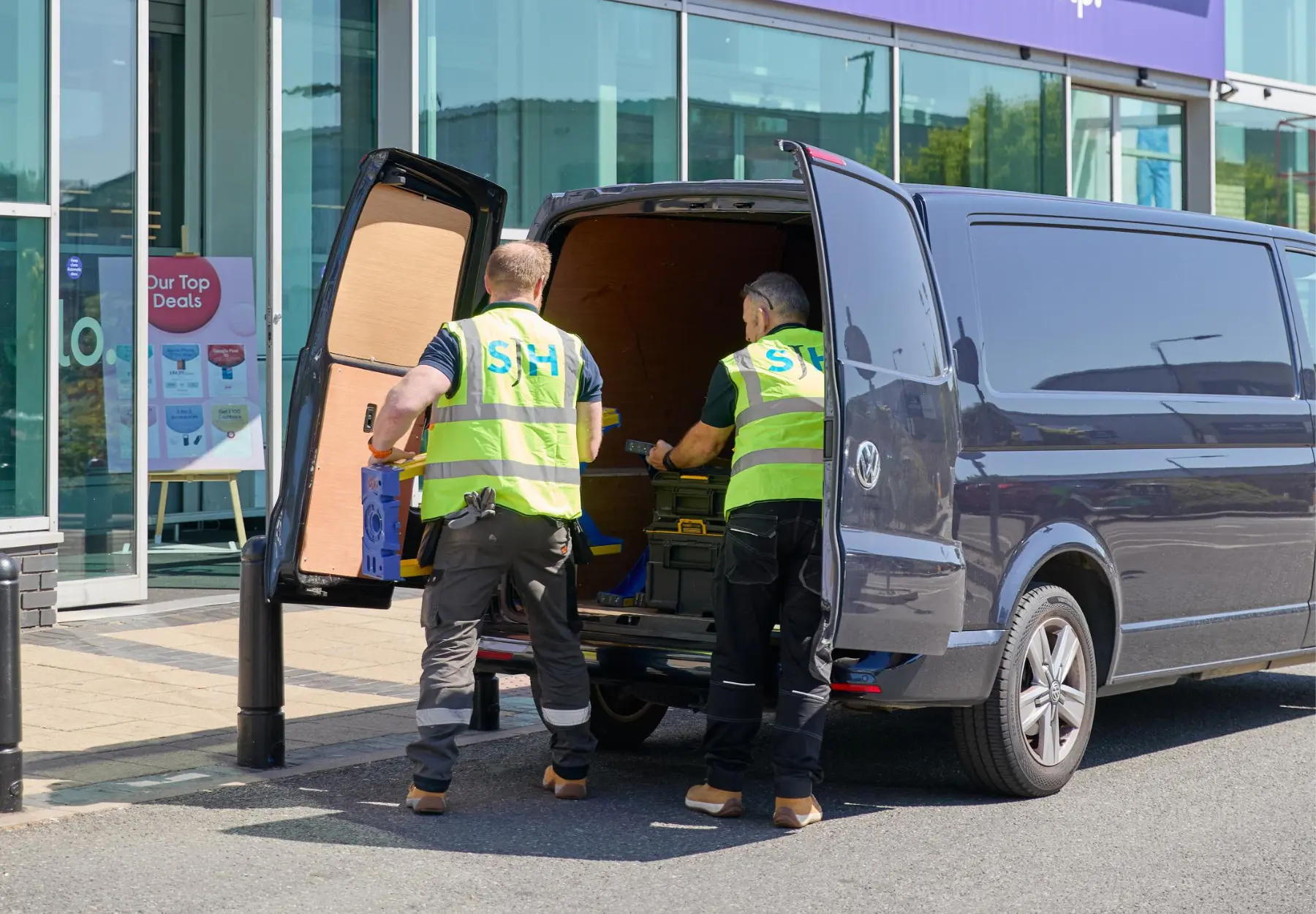 SJH installation team unloading equipment from van outside Currys store