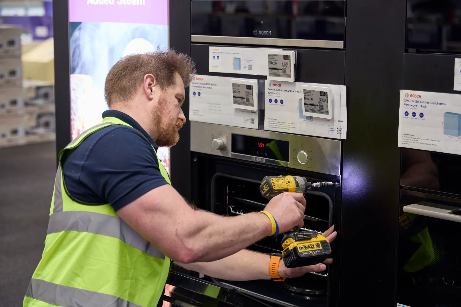 SJH Engineer installing built in oven display unit in Currys store