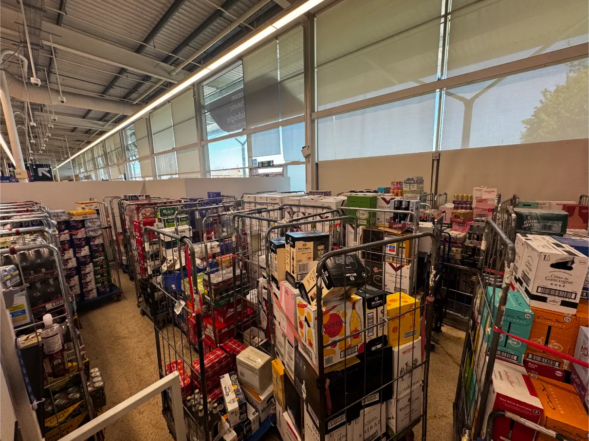Stock cages filled with retail products organised in a Tesco shop floor warehouse area