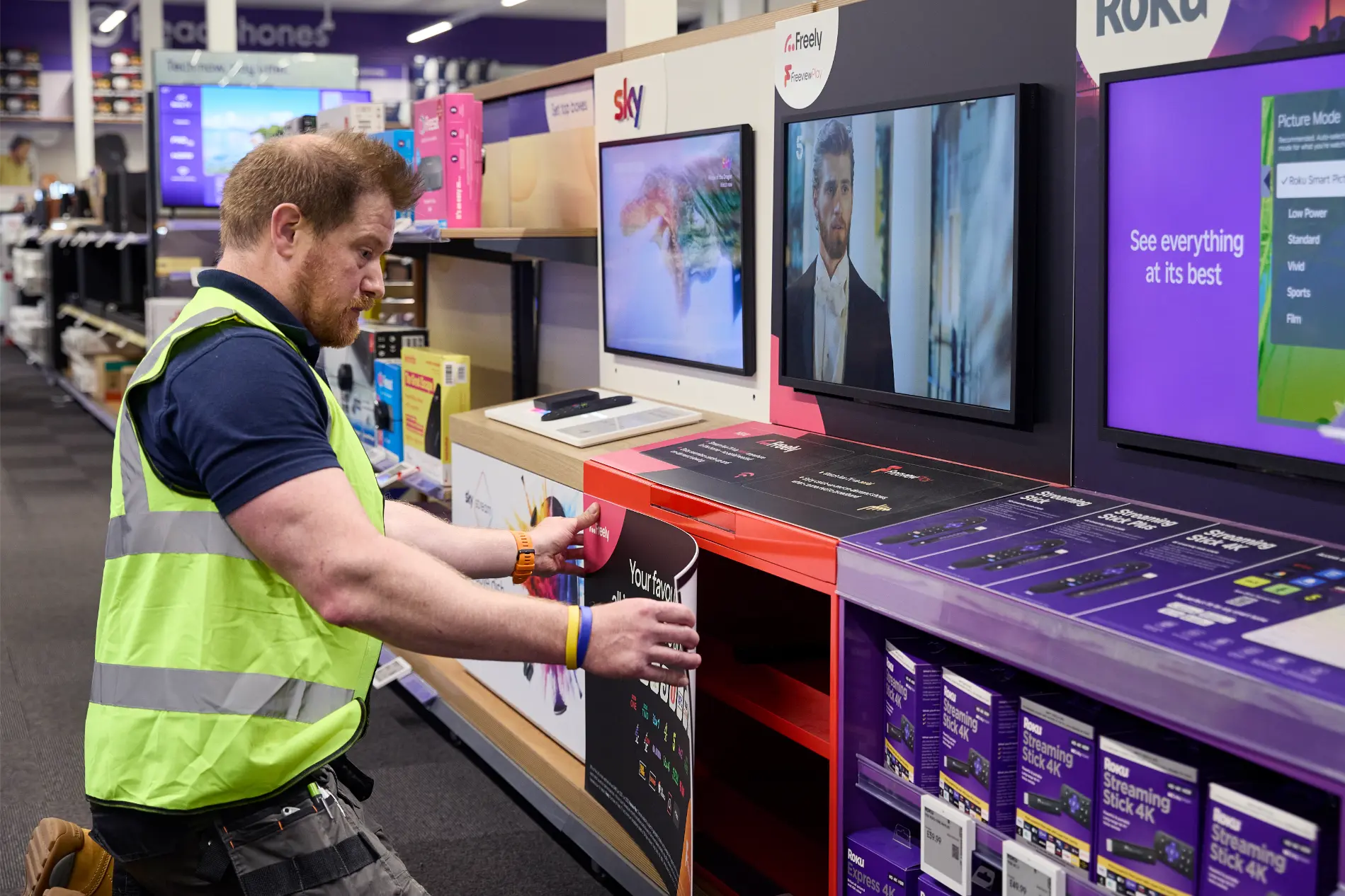 SJH team member adding final touches to TV and media display units on Currys shop floor